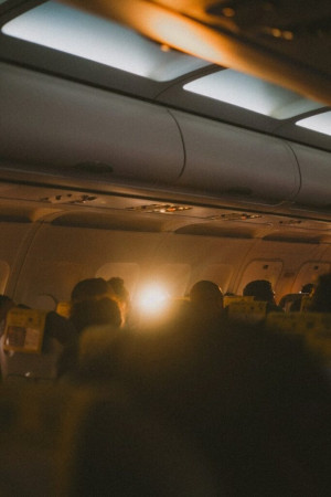 Airplane cabin with passengers silhouetted by bright light