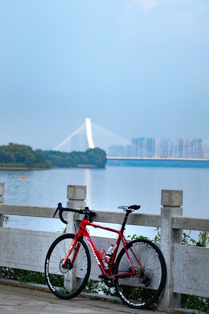 a red bike parked next to a wooden fence