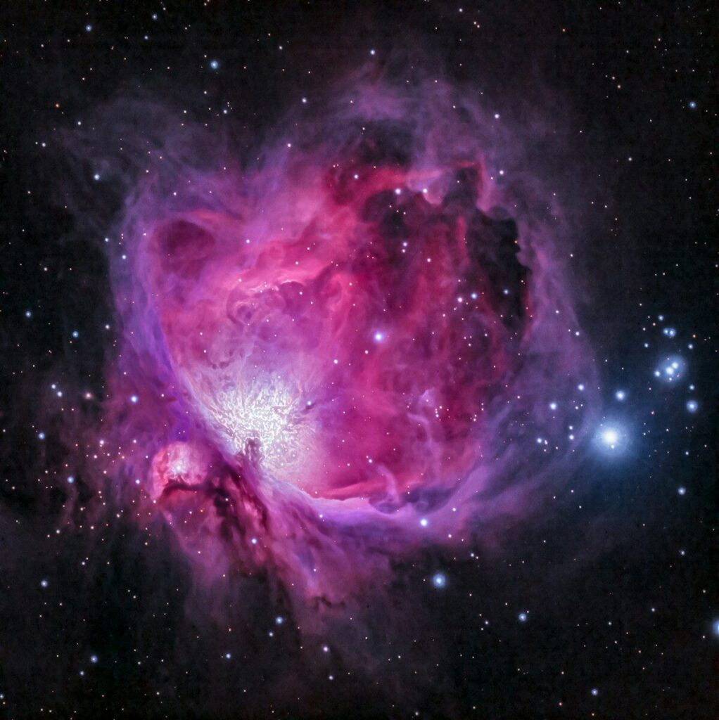 orion nebula photograph in pink purple